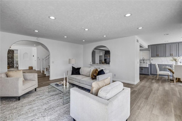 3118 Calle Grande, San Clemente, CA 92672 - living room featuring recessed lighting, light wood-type flooring, a textured ceiling, baseboards, and stairs