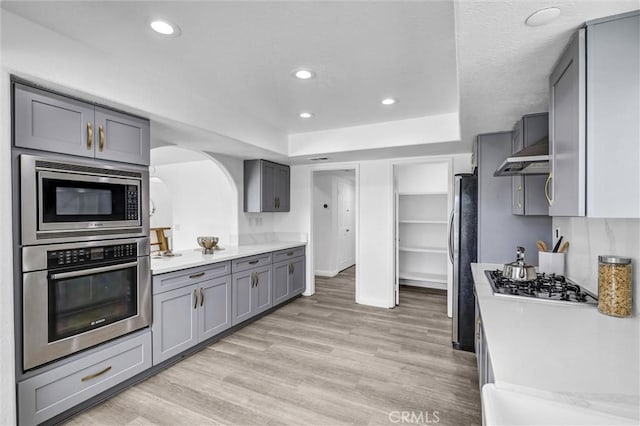 3118 Calle Grande, San Clemente, CA 92672 - kitchen with light wood finished floors, light countertops, gray cabinets, and appliances with stainless steel finishes