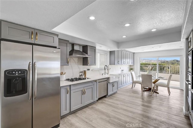 3118 Calle Grande, San Clemente, CA 92672 - kitchen featuring a sink, wall chimney exhaust hood, stainless steel appliances, a textured ceiling, and gray cabinets