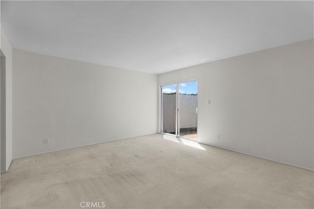 spare room featuring light carpet