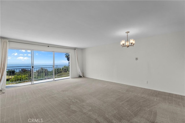 spare room with carpet floors and a chandelier