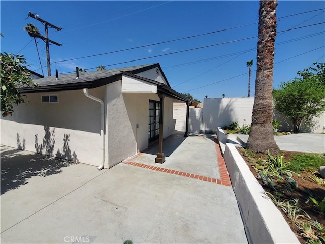 1741 Glenwood Rd, Glendale, CA 91201 - view of side of home featuring stucco siding, a patio, fence, and french doors