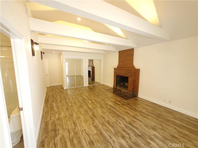 1741 Glenwood Rd, Glendale, CA 91201 - unfurnished living room featuring a brick fireplace, light wood finished floors, vaulted ceiling, and baseboards