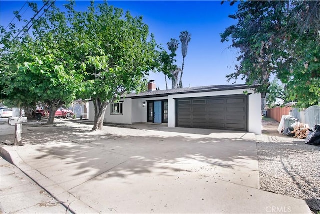view of front of property featuring concrete driveway, stucco siding, and a garage