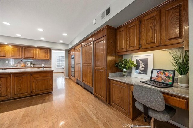 112 Morgan Ranch Rd, Glendora, CA 91741 - kitchen with brown cabinetry, light wood finished floors, recessed lighting, backsplash, and light stone counters