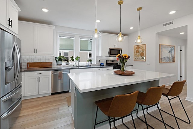 10456 Newbliss Way, Mira Mesa, CA 92126 - kitchen with stainless steel appliances, a sink, tasteful backsplash, a center island, and a breakfast bar