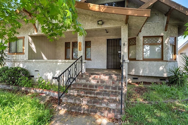 doorway to property featuring covered porch and crawl space