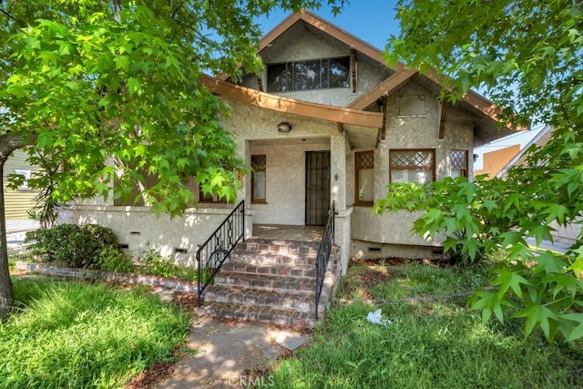 view of front of home featuring stucco siding and crawl space