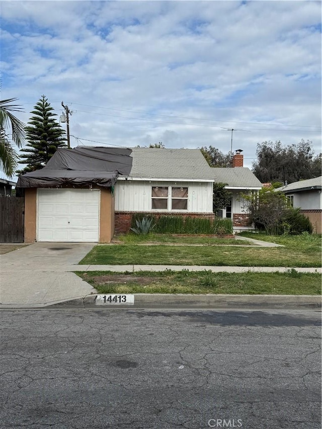 ranch-style house featuring driveway, a garage, fence, and a front yard