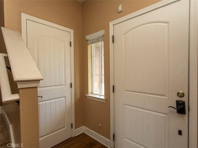 entryway featuring baseboards and dark wood finished floors