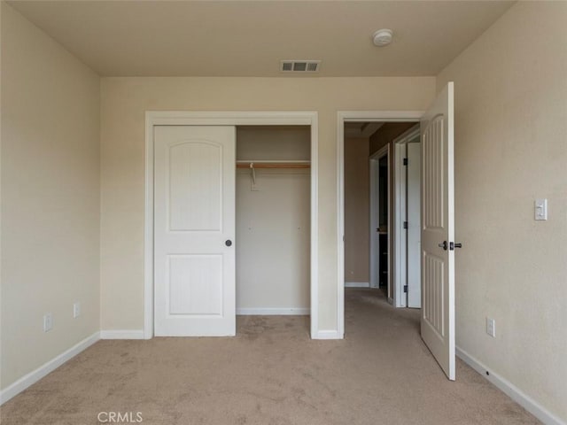 unfurnished bedroom with light colored carpet, baseboards, and visible vents