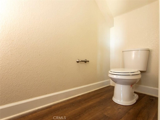 bathroom with baseboards, toilet, and wood finished floors