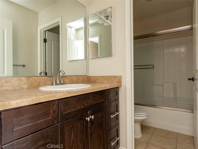 full bathroom featuring vanity, bath / shower combo with glass door, tile patterned floors, and toilet