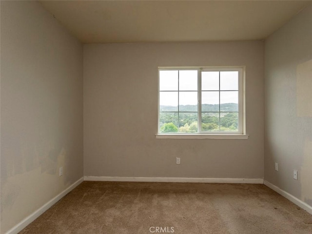 empty room featuring carpet floors and baseboards