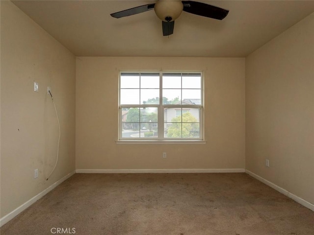 empty room featuring carpet floors, ceiling fan, and baseboards