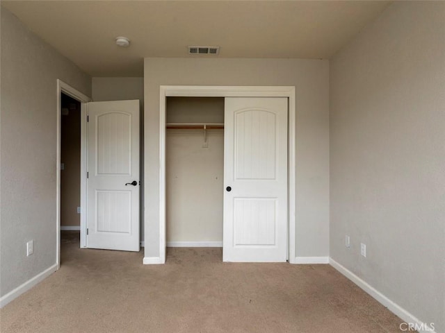 unfurnished bedroom featuring carpet flooring, baseboards, visible vents, and a closet