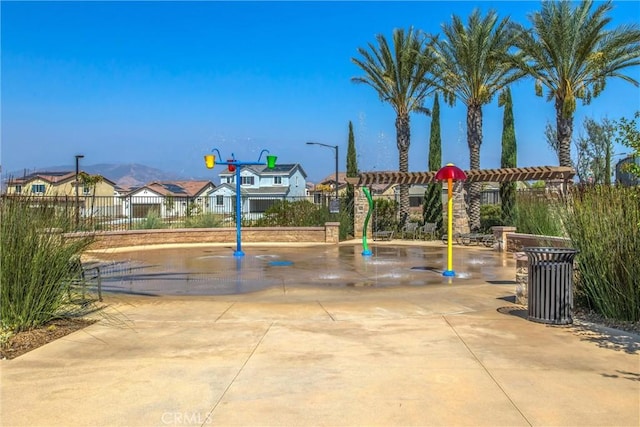 view of community with fence, a pergola, and a residential view