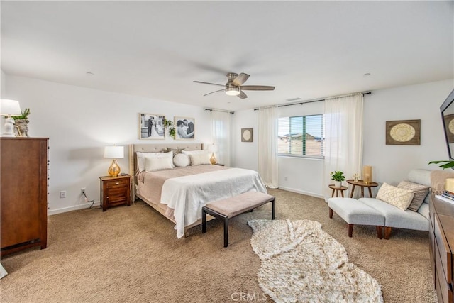 bedroom with baseboards, ceiling fan, and light carpet