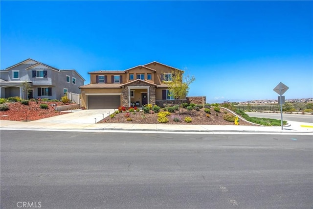 view of front facade with an attached garage, stone siding, stucco siding, concrete driveway, and a tiled roof