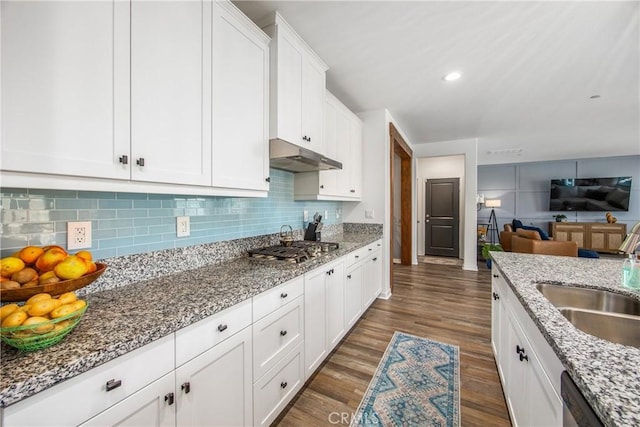 kitchen featuring a sink, stainless steel appliances, white cabinetry, dark wood-type flooring, and under cabinet range hood