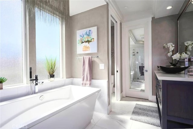 full bathroom with a freestanding tub, vanity, and marble finish floor