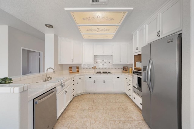 1366 Via Cibola, Oceanside, CA 92057 - kitchen with a sink, appliances with stainless steel finishes, tile counters, and white cabinetry