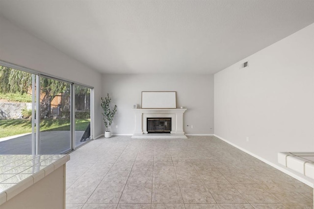 1366 Via Cibola, Oceanside, CA 92057 - unfurnished living room featuring a glass covered fireplace, baseboards, light tile patterned flooring, and visible vents