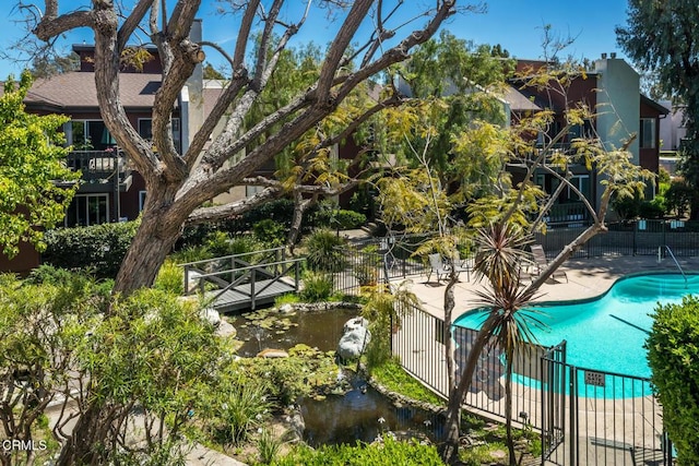 pool featuring fence and a patio area