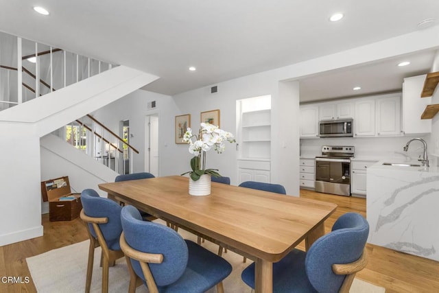 dining space featuring recessed lighting, light wood finished floors, visible vents, and stairway