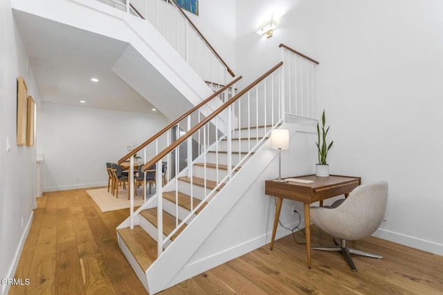 stairs with baseboards, recessed lighting, and wood finished floors