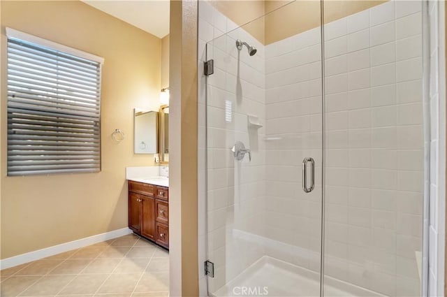bathroom with tile patterned flooring, baseboards, vanity, and a shower stall