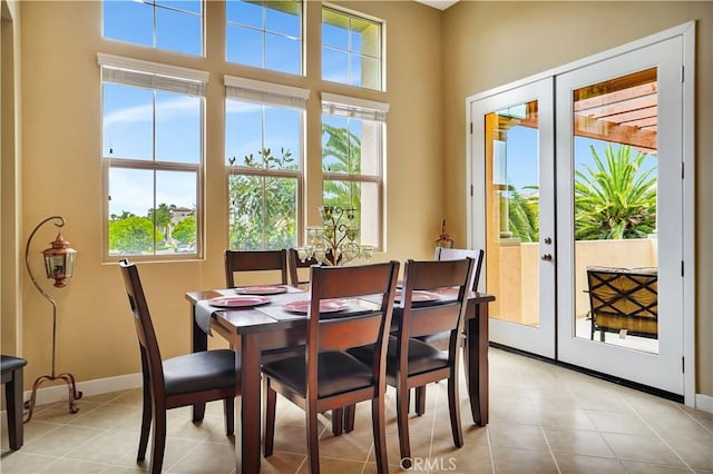 dining room featuring light tile patterned floors, baseboards, and french doors