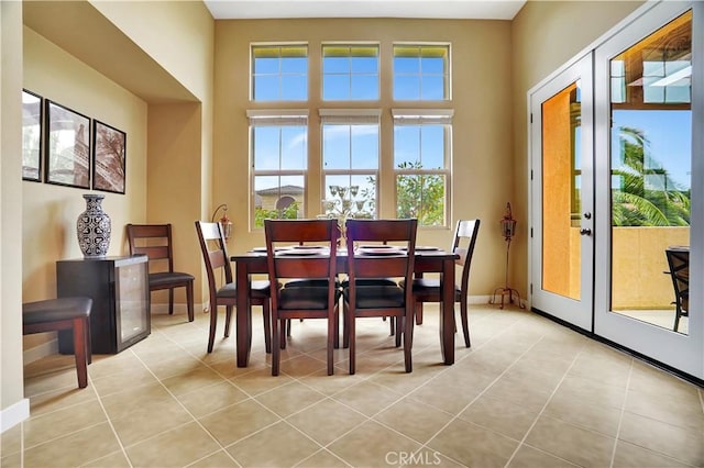 dining space with light tile patterned flooring, baseboards, and french doors