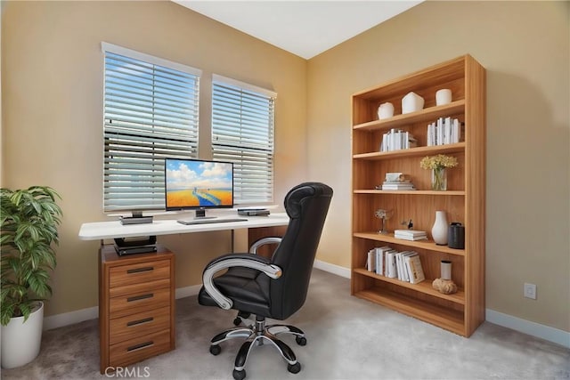 carpeted home office featuring baseboards