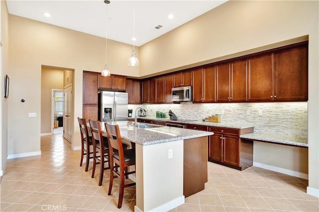 kitchen featuring appliances with stainless steel finishes, tasteful backsplash, a sink, a high ceiling, and light tile patterned flooring