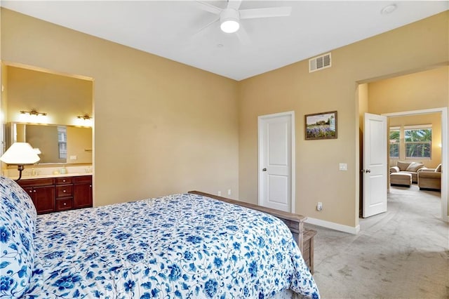 bedroom featuring ceiling fan, visible vents, baseboards, ensuite bathroom, and light carpet