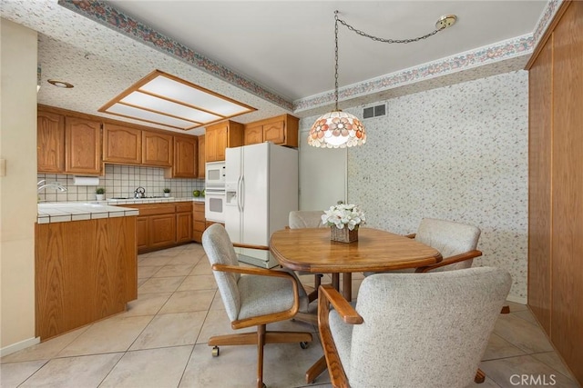 dining area featuring wallpapered walls, visible vents, and light tile patterned floors