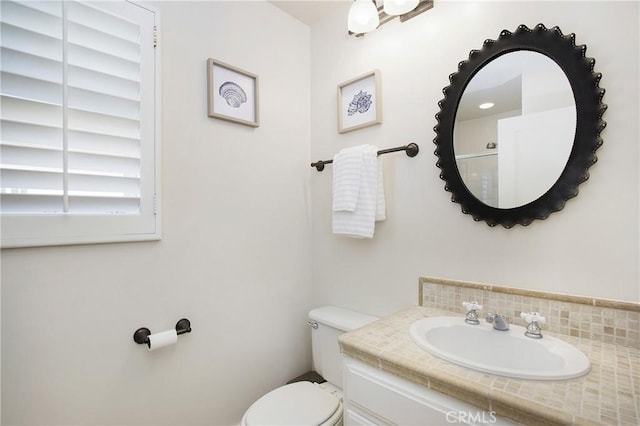 bathroom with backsplash, toilet, and vanity