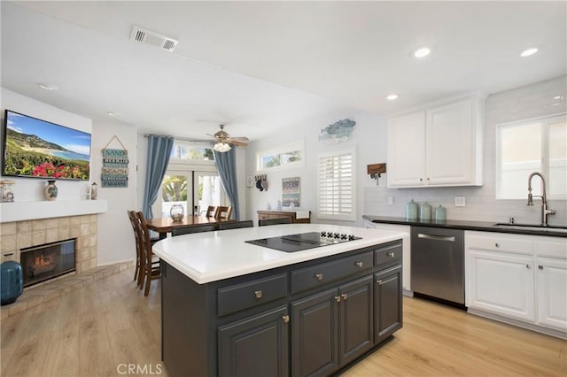 kitchen featuring white cabinetry, black electric stovetop, a sink, and dishwasher