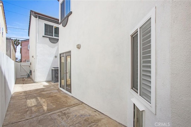 exterior space featuring a patio, cooling unit, stucco siding, and fence