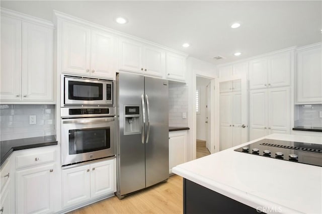 kitchen featuring white cabinetry, appliances with stainless steel finishes, and backsplash