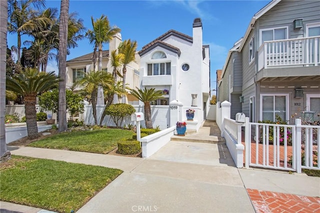 view of front of house featuring fence private yard and a balcony