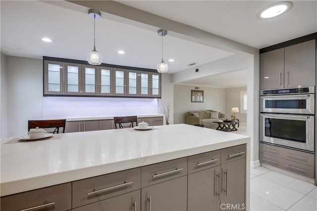 kitchen featuring stainless steel double oven, pendant lighting, gray cabinetry, recessed lighting, and light tile patterned flooring