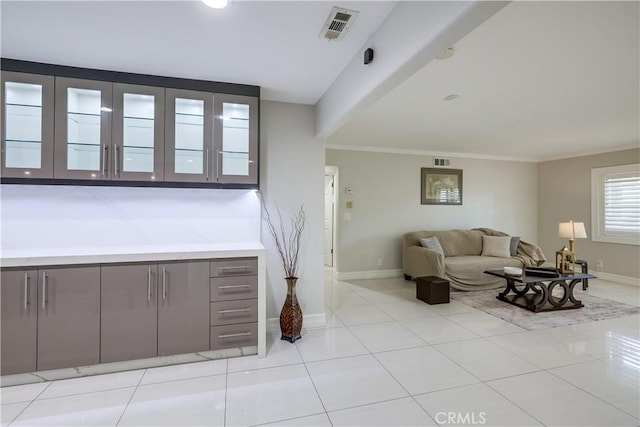 living area with light tile patterned floors, baseboards, and visible vents