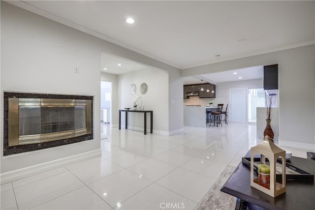 living area with crown molding, a multi sided fireplace, recessed lighting, baseboards, and light tile patterned floors
