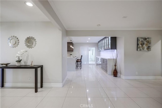 hall with baseboards, recessed lighting, crown molding, and light tile patterned floors