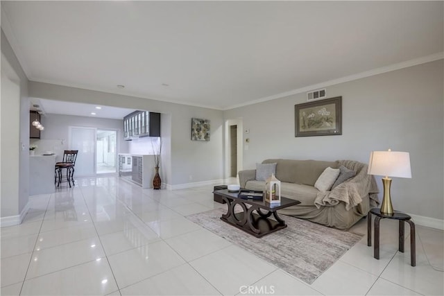 living room featuring baseboards, ornamental molding, and tile patterned floors