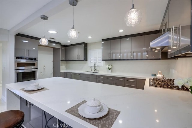 kitchen with pendant lighting, appliances with stainless steel finishes, modern cabinets, a sink, and under cabinet range hood