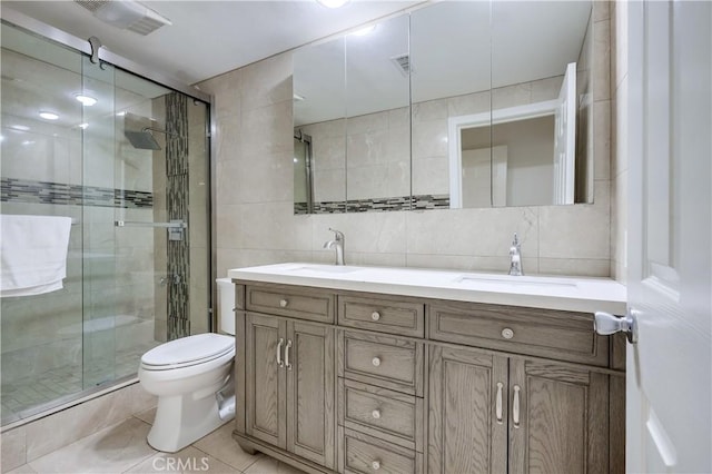 bathroom with tile walls, a sink, visible vents, and a stall shower