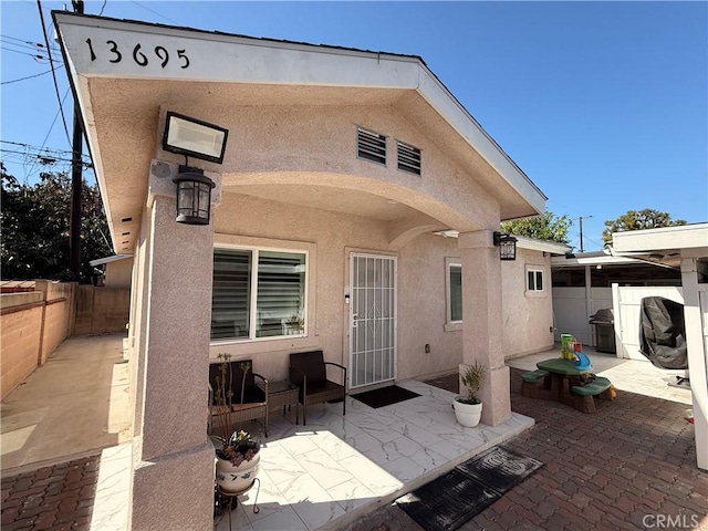 back of property with a patio, fence, and stucco siding